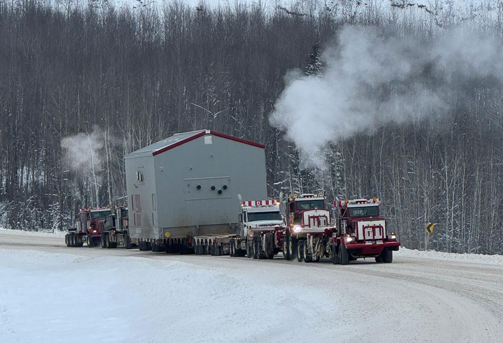 Donald Rigging transporting a heavy load on a snowy mountain road.